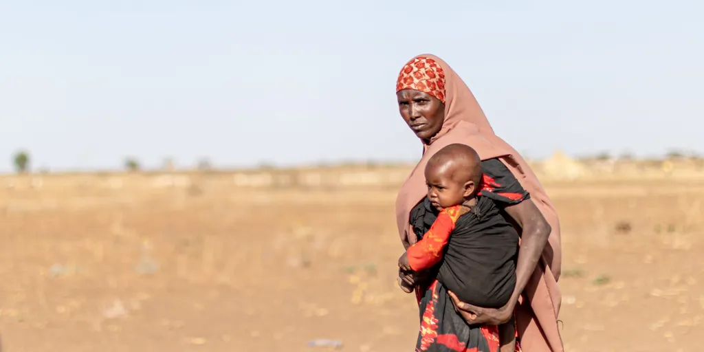 Displaced woman holds baby. Thousands of families have been displaced due to recent climate change and droughts in Ethiopia's Somali regions.