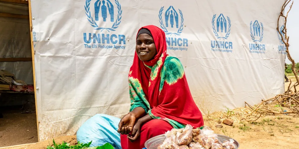 Sudanese refugee Hawa Issat in front of her temporary shelter