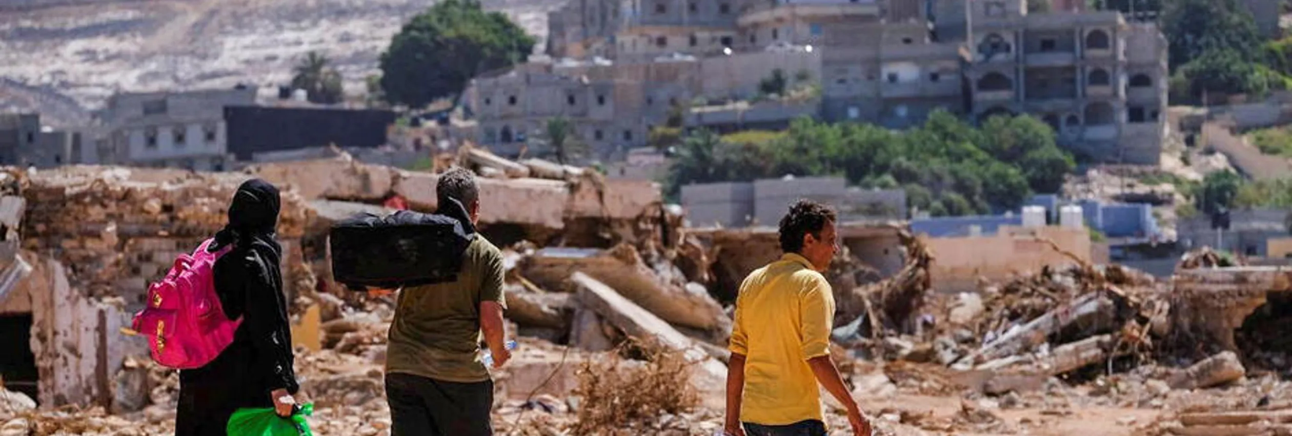 Libya_people-carrying-belongings-amidst-flood-debris