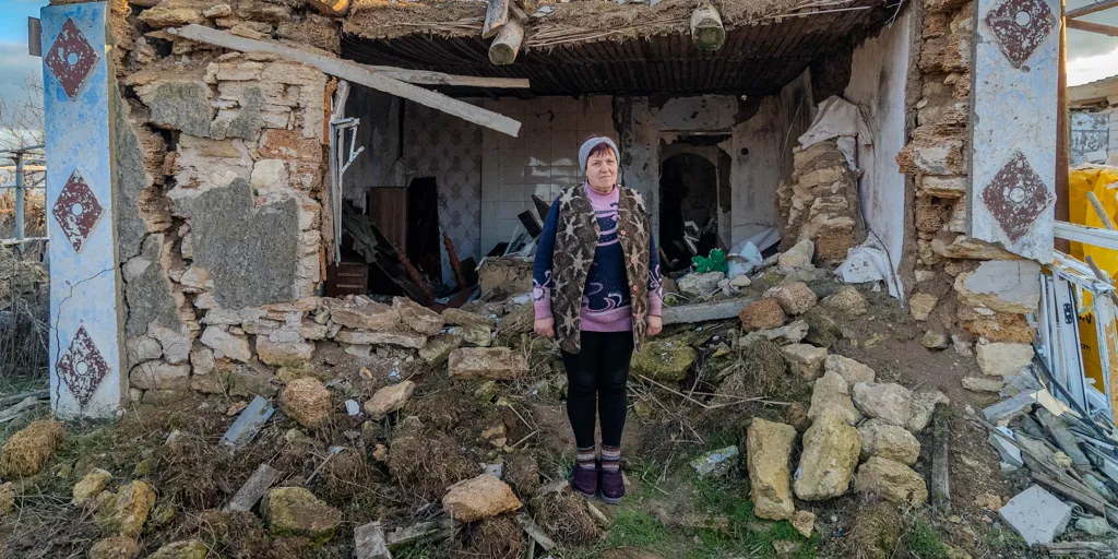 Ukraine_Valentyna stands outside her destroyed home in Mykolaiv, Ukraine