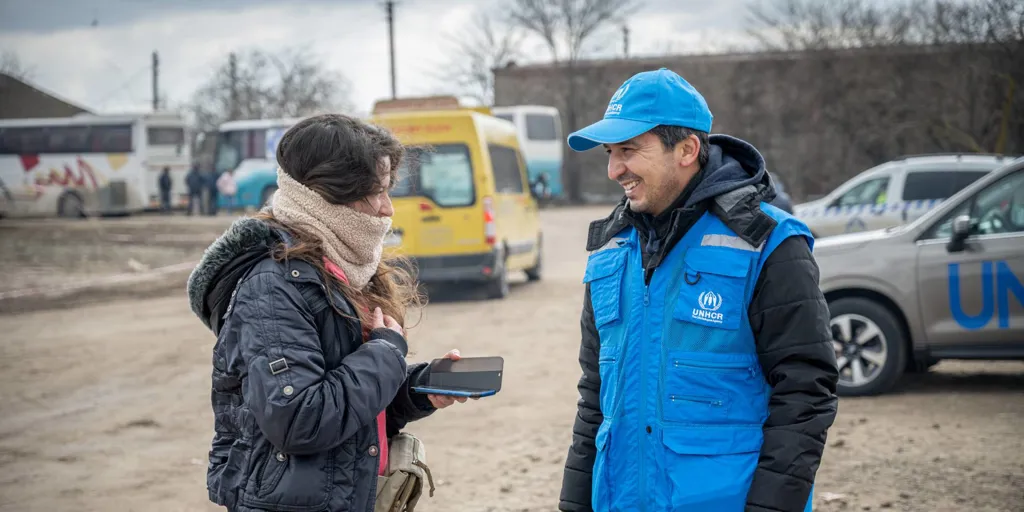 UNHCR’s Representative in Romania, Batyr Sapbyiev, assists a refugee at the Palanca border crossing in Moldova.